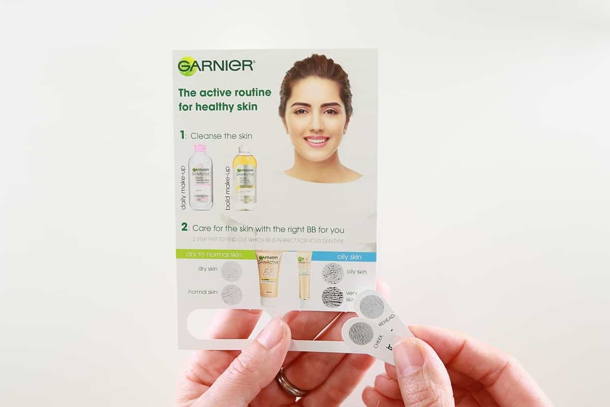 Garnier Skincare Routine Guide with Skin Type Test Strips Held by Hands, Featuring Model and Product Images for