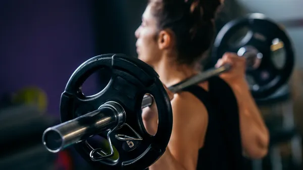 Person training with a barbell in a gym, a visual metaphor for practising demo thinking as a trainable skill