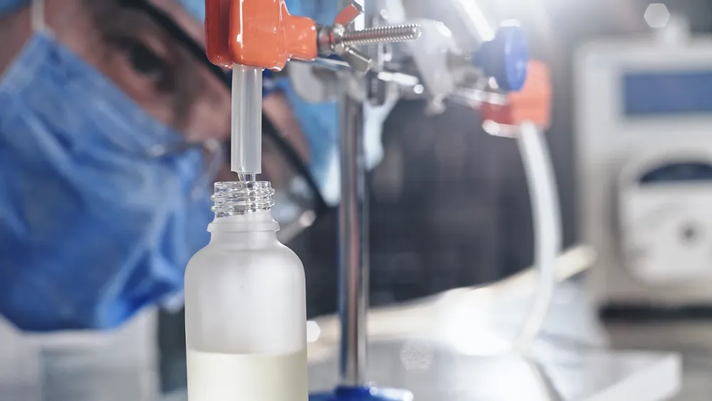 A dropper filling a frosted bottle in a healthcare and OTC product demo